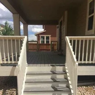 Deck with steps leading to covered porch, view of house exterior.