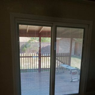 Sliding glass door, with a screened panel. View to outdoor deck and fence.