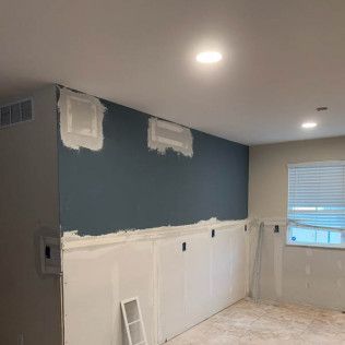 Room with blue accent wall, drywall installation in progress. Light fixtures, vents, window with blinds.
