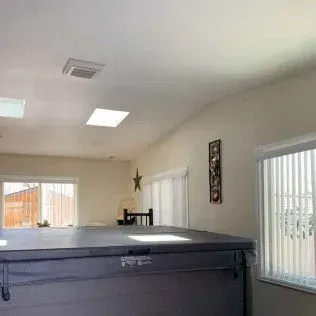 Hot tub cover in a light-filled interior with windows and skylights.