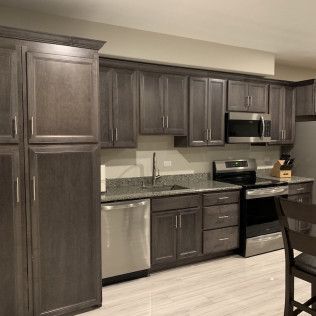 Gray kitchen cabinets with stainless steel appliances.