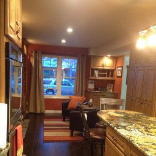 Kitchen with a built-in oven, cabinets, seating area with a window, and a countertop.