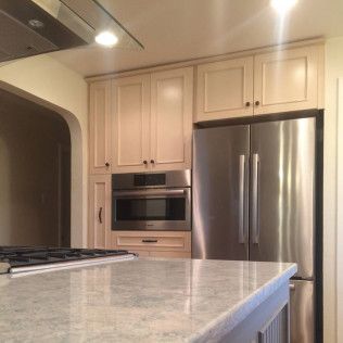 Kitchen with light wood cabinets, stainless steel appliances, and a granite countertop.