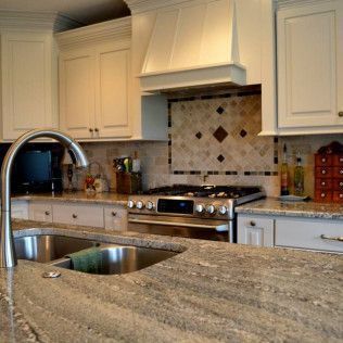 Kitchen with granite countertops, stainless steel appliances, and white cabinets.