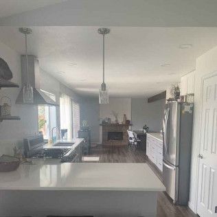 Kitchen with white counters, stainless steel appliances, and a fireplace in the background.
