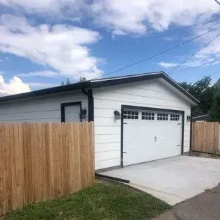 Dark kitchen cabinets with stainless steel refrigerator and shelf with decorations.
