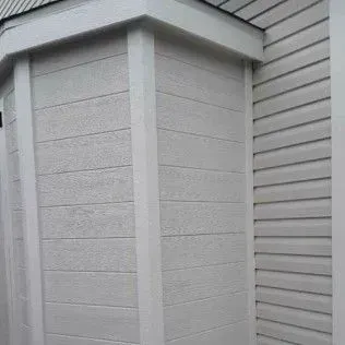White house exterior with horizontal siding and vertical trim.