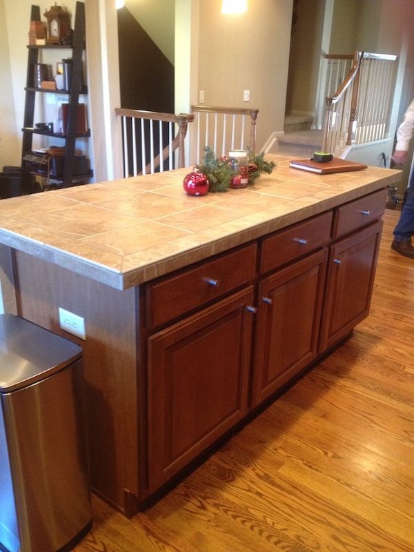 Kitchen island with brown cabinets, light countertop, and holiday decor on top.