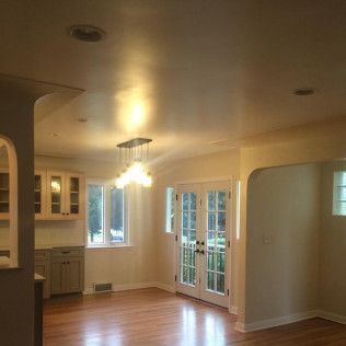 Dining room with hardwood floors, cabinets, French doors, and a chandelier.