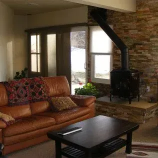 Leather sofa, fireplace, and sliding door in a living room with brick accent wall.
