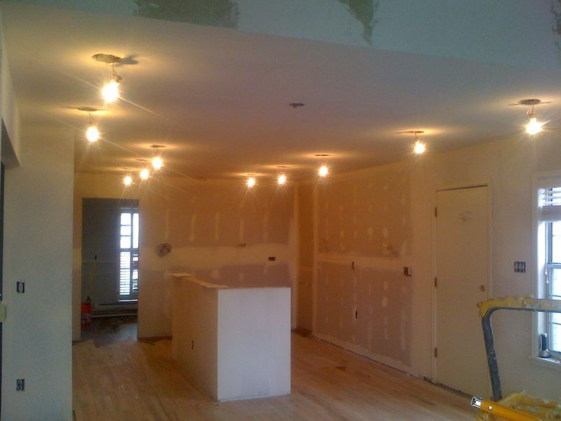 Room with exposed light fixtures, drywall, and unfinished construction.