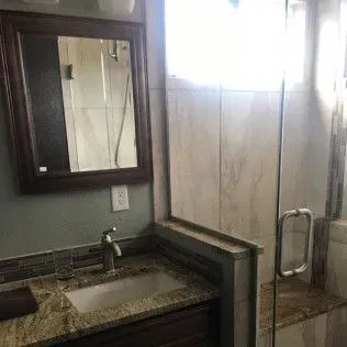 Bathroom with a mirror, vanity, and glass shower.