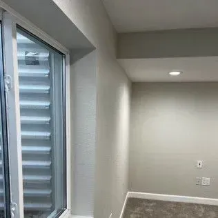 Basement room with a window, white walls, and a recessed ceiling light.