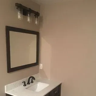 Bathroom with a mirror, vanity, and light fixture.