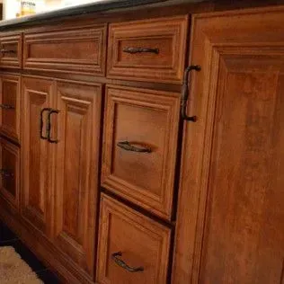 Wooden cabinets with dark hardware and a black countertop.