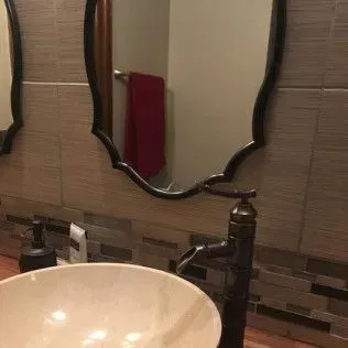 Bathroom sink with decorative mirror and faucet.