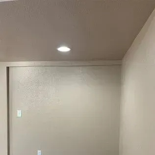 Empty room with beige walls and a recessed ceiling light.