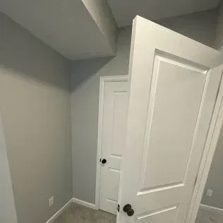 Interior view of a room with two white doors and gray walls.