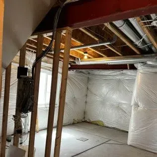 Basement with exposed framing, insulation, electrical wiring, and ductwork.