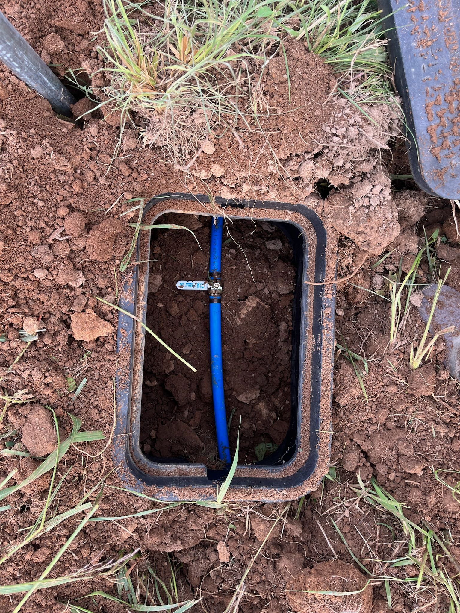 A pipe is being installed in the dirt in a field.
