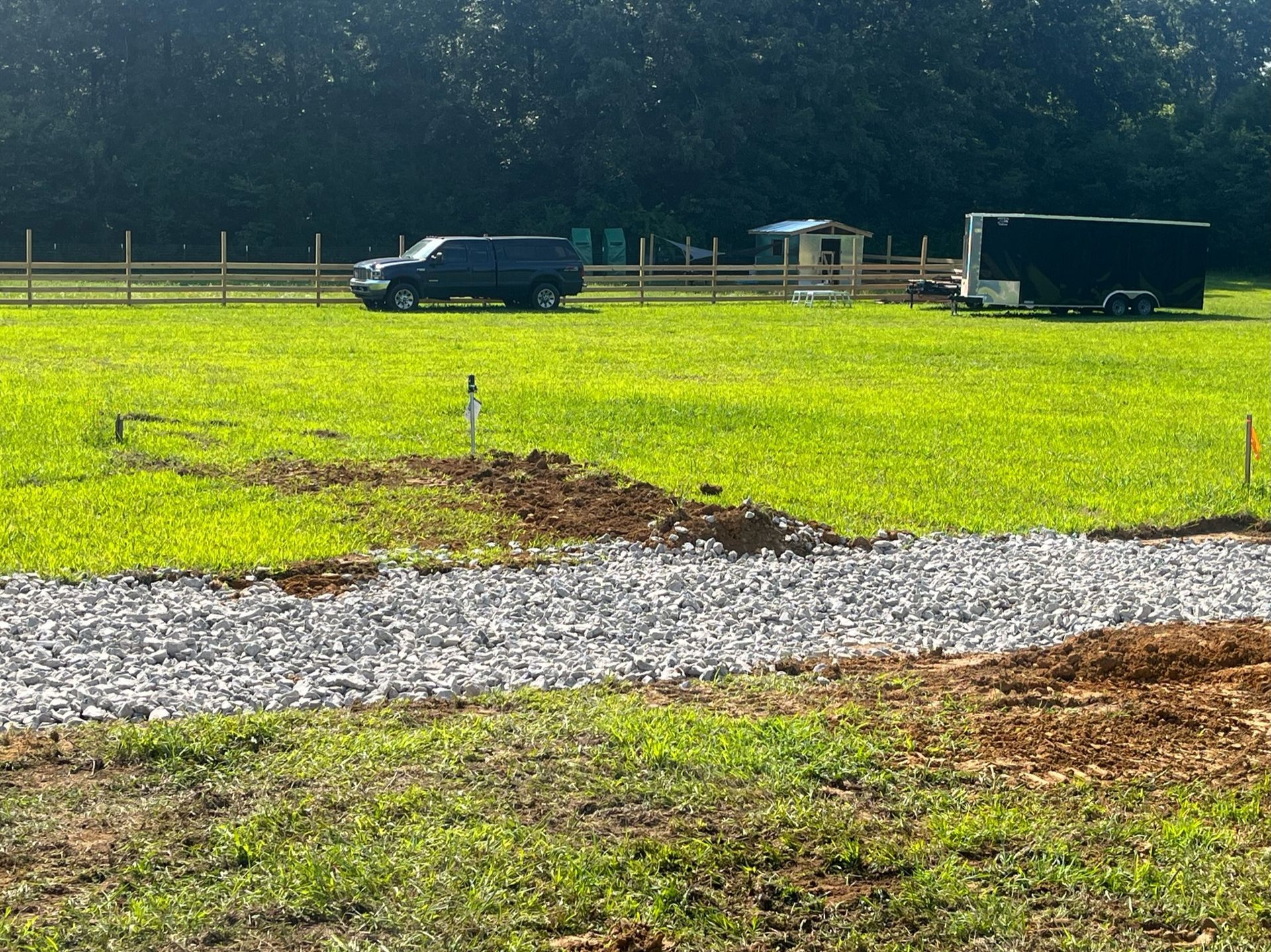 A truck and trailer are parked in a grassy field