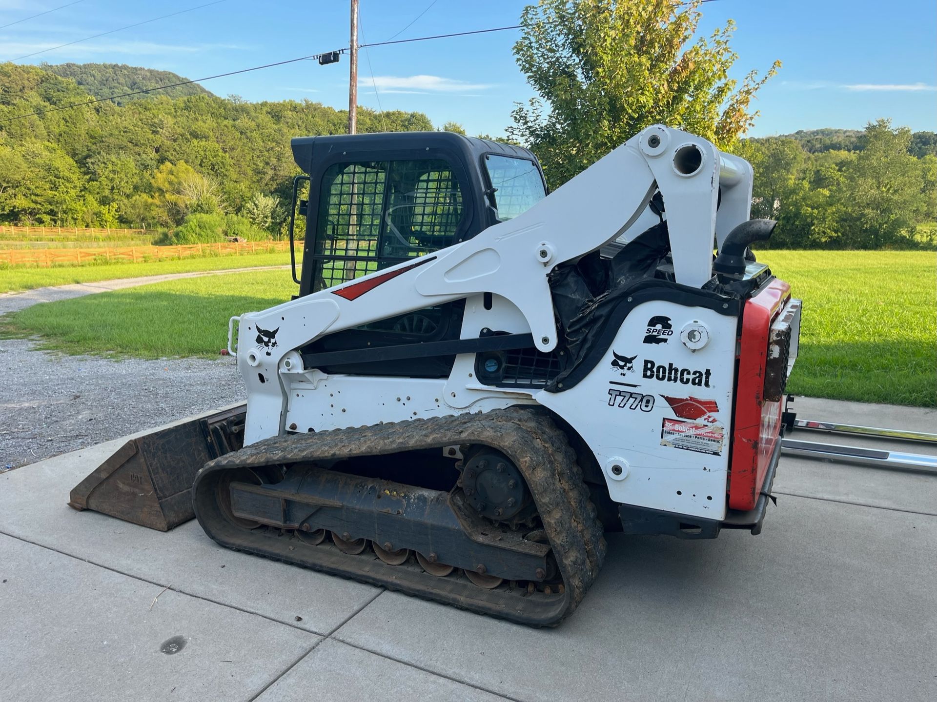 A bobcat skid steer is parked on the side of the road.