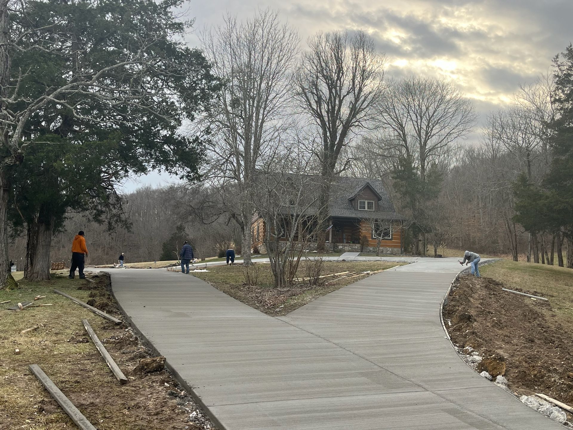 A concrete driveway with a house in the background