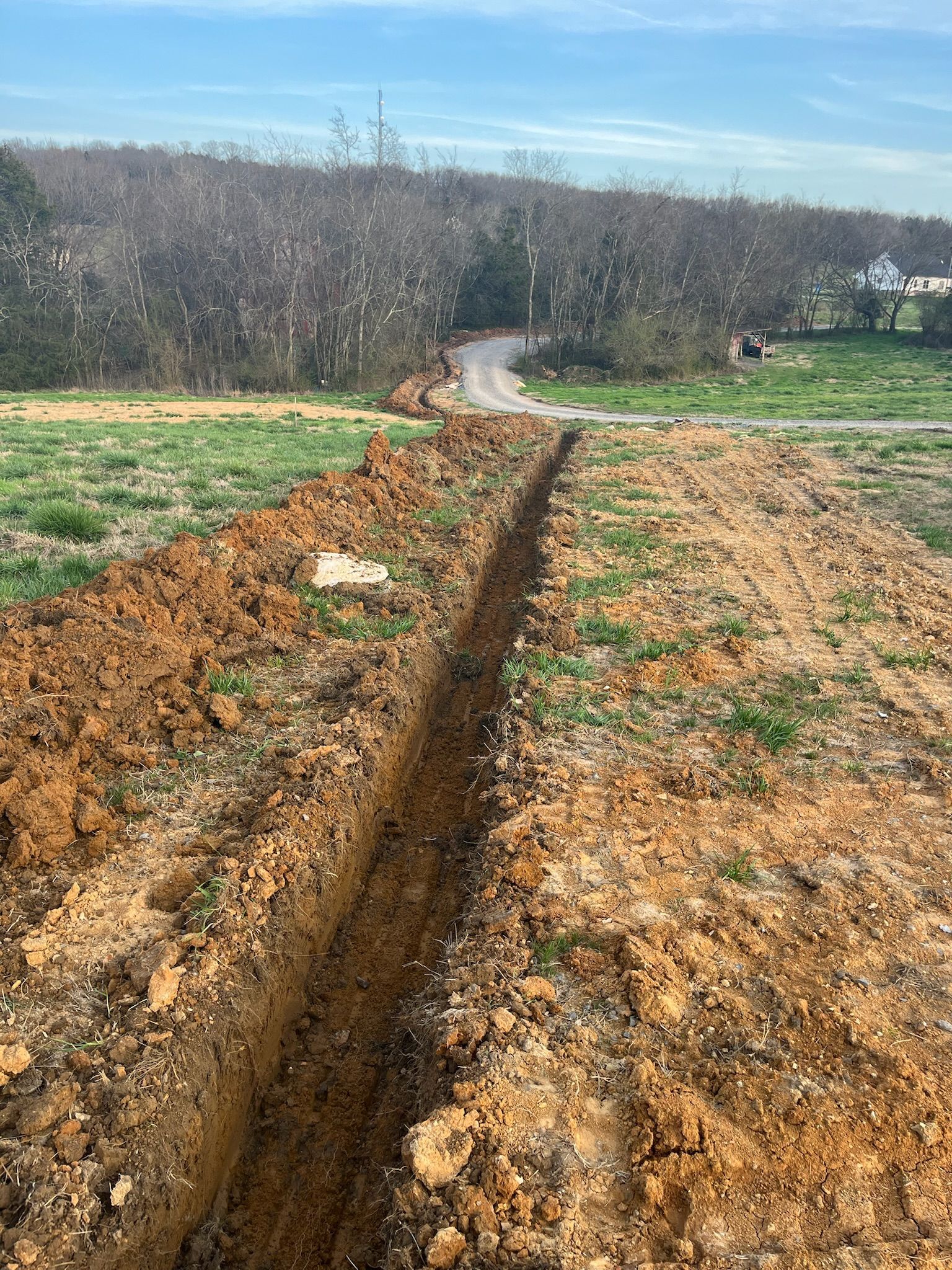 A dirt road is going through a field of dirt.