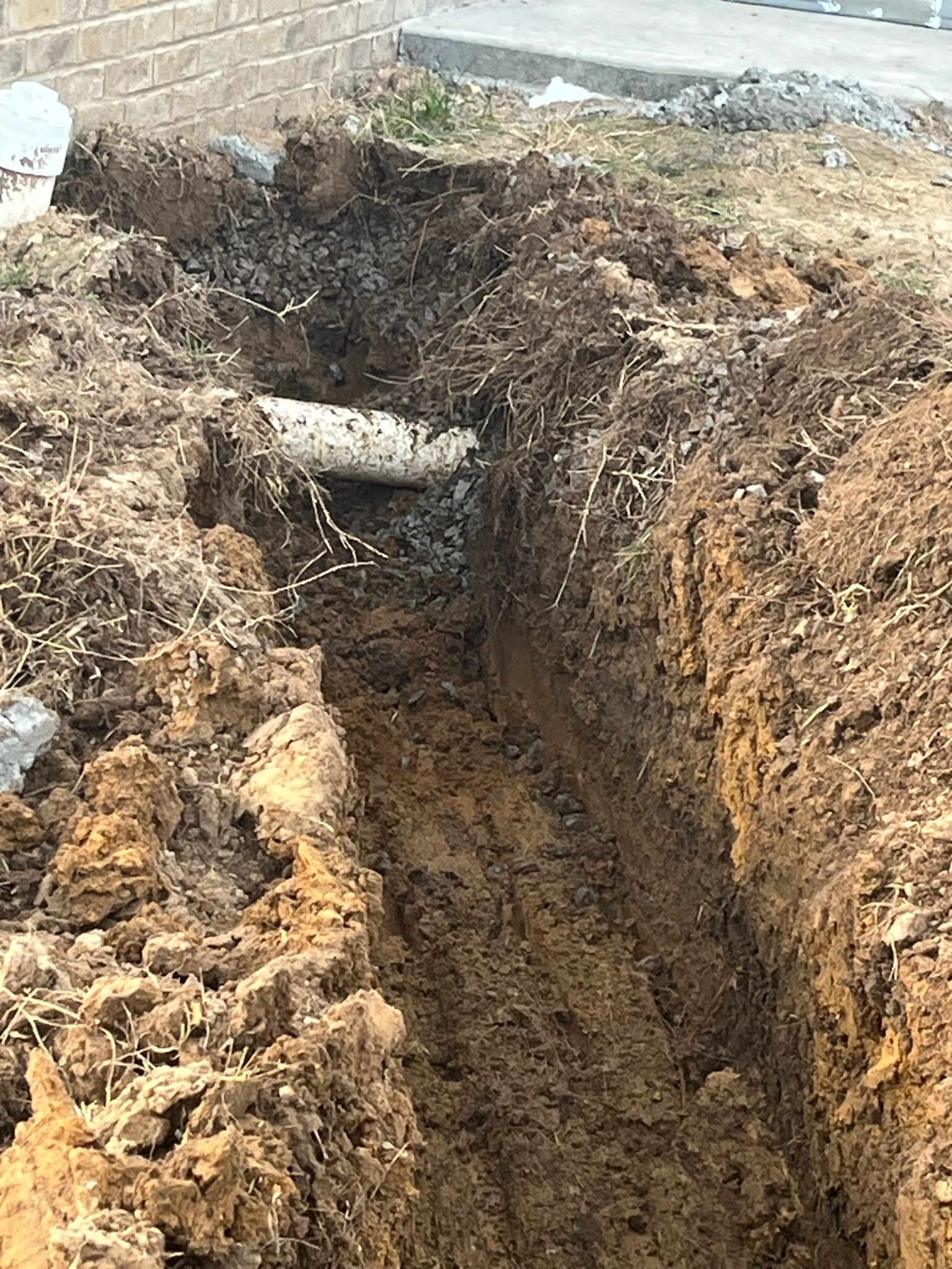 A large hole in the ground with a pipe in it.