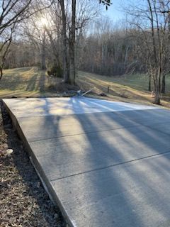 A concrete driveway is being built in the middle of a forest.