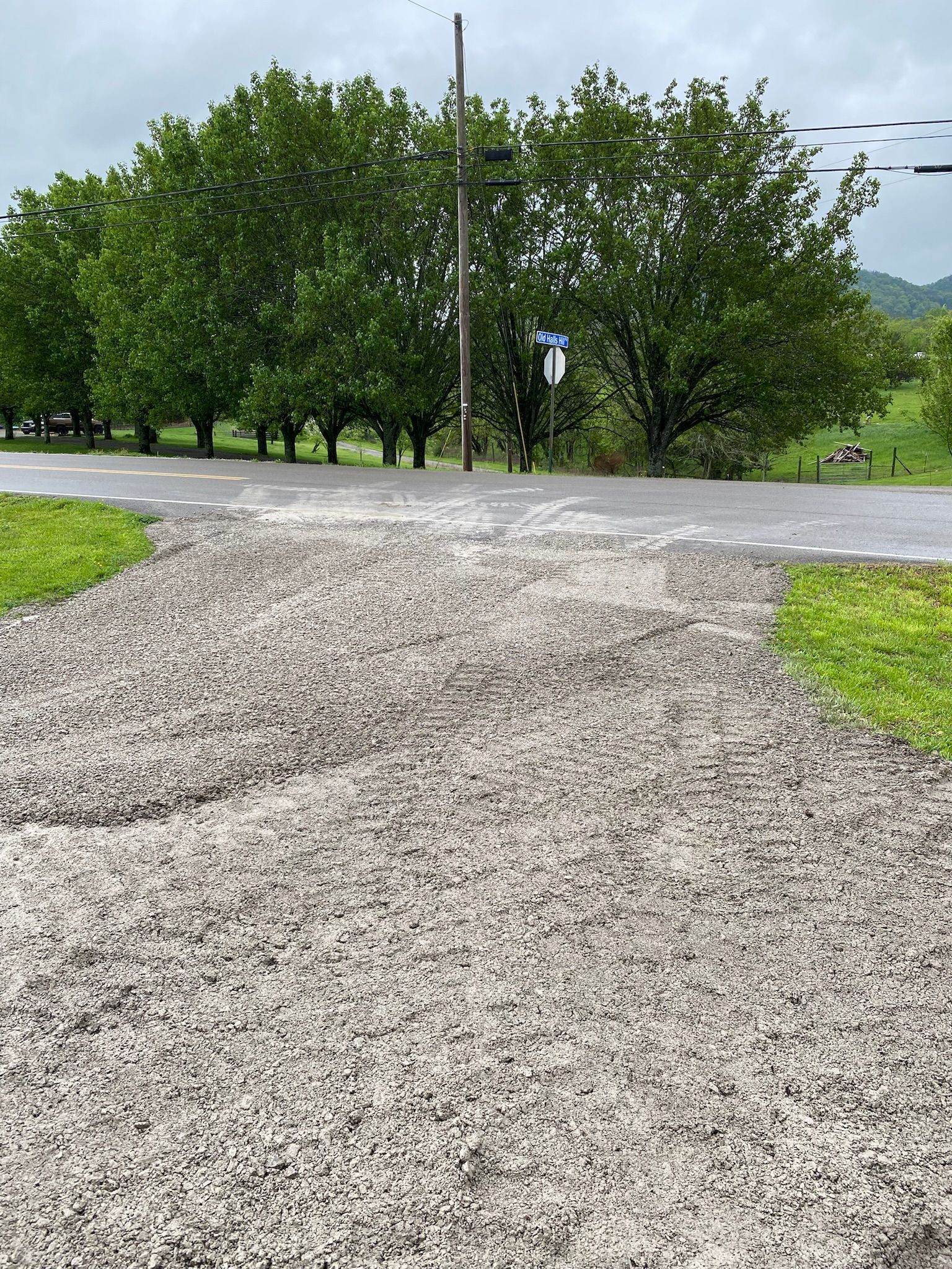 A gravel road with trees on the side of it.