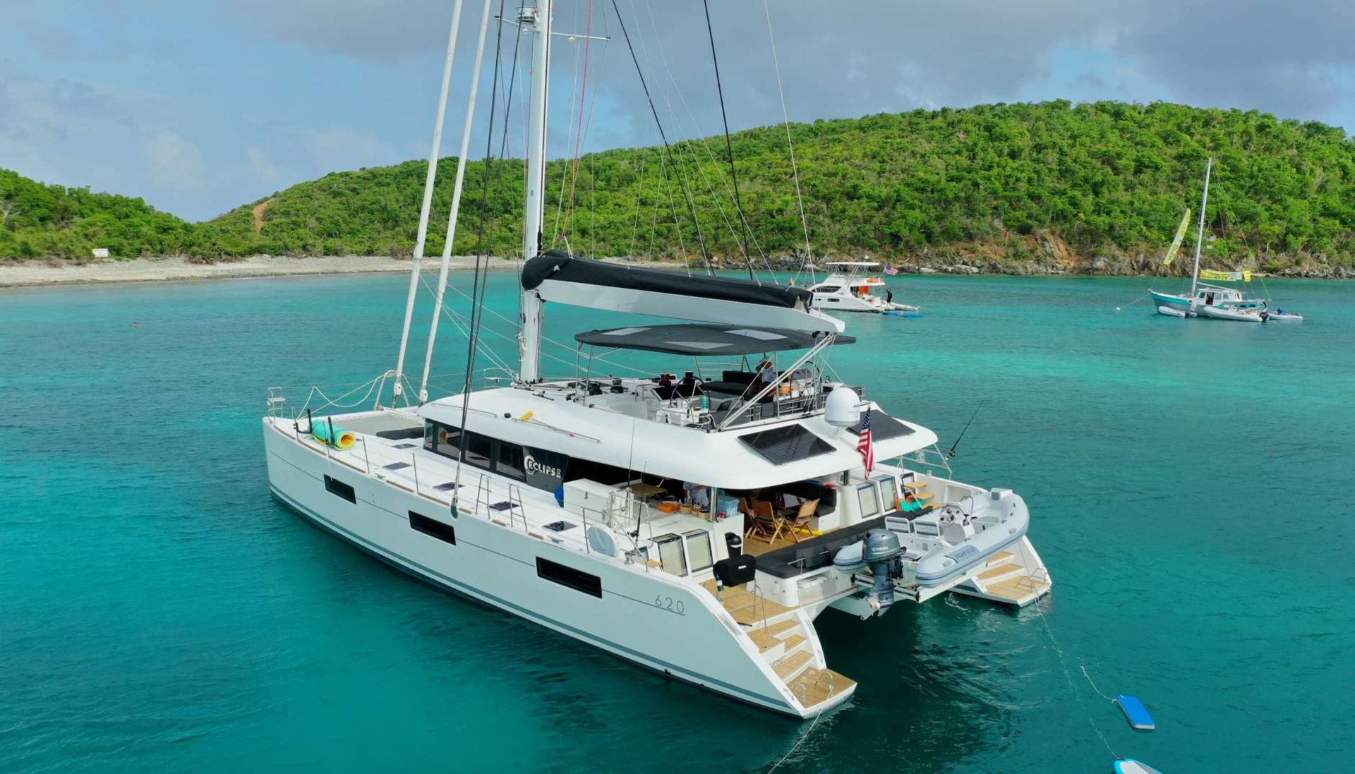 A large white sailboat is floating on top of a body of water.