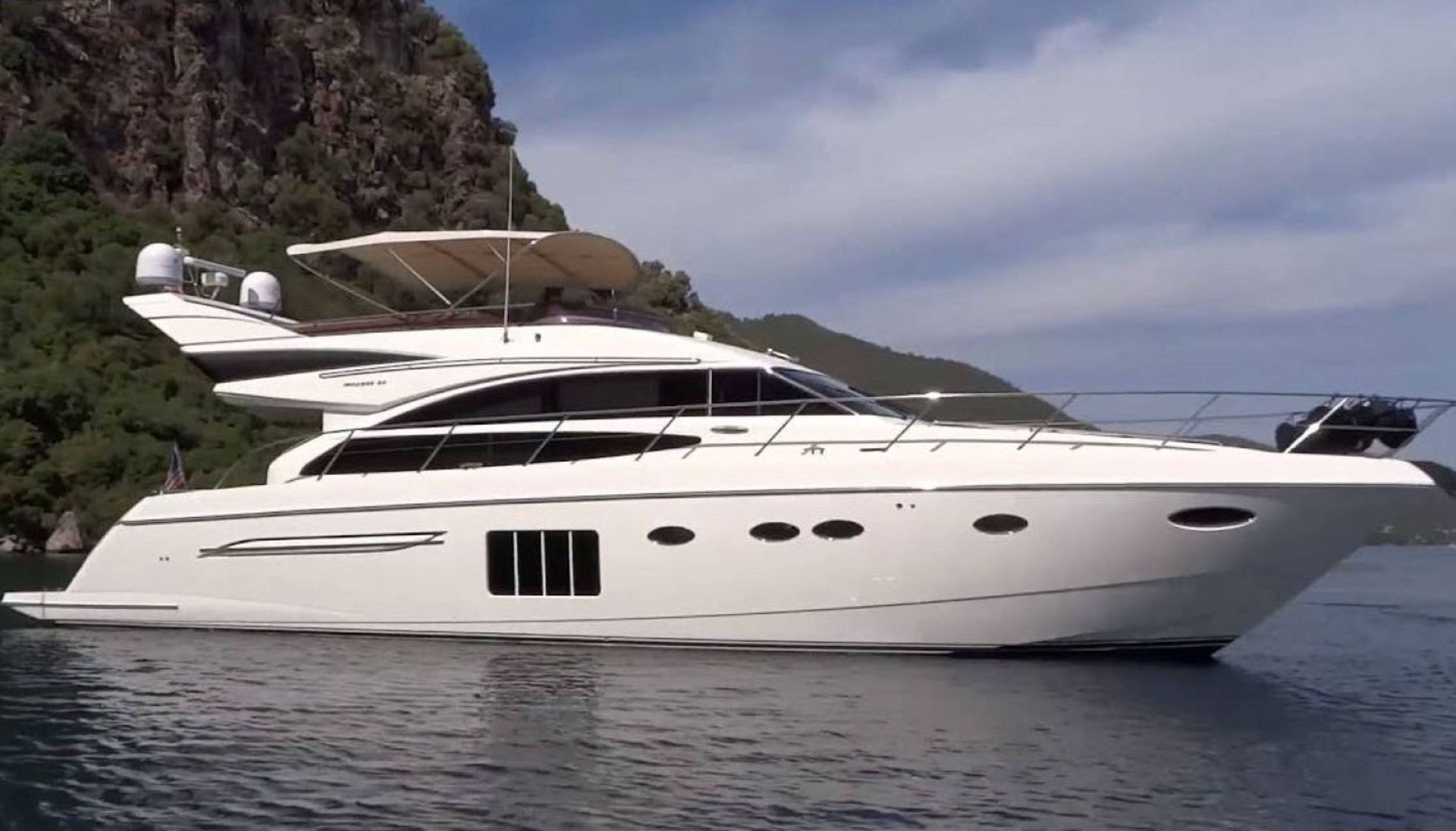 A large white yacht is floating on top of a body of water.