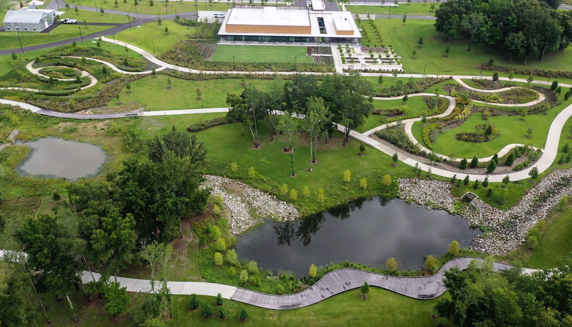 An aerial view of a park with a pond and trees