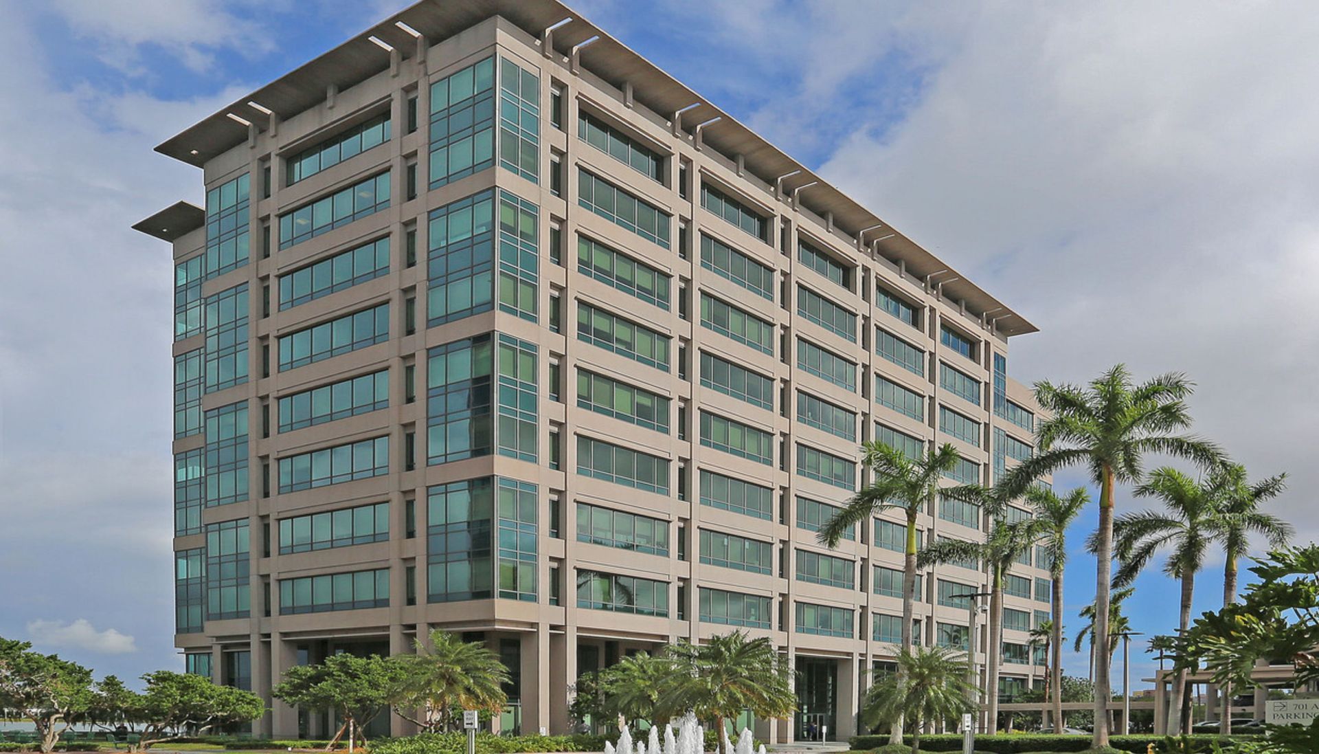 A large building with a lot of windows and palm trees in front of it