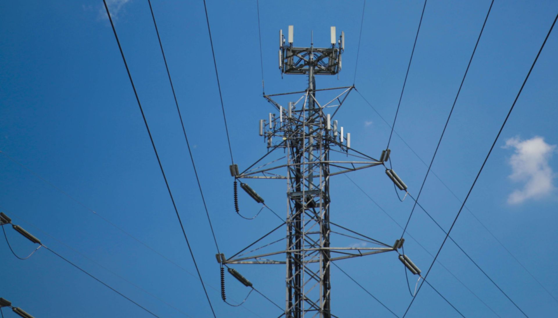 A telephone pole with a blue sky in the background.