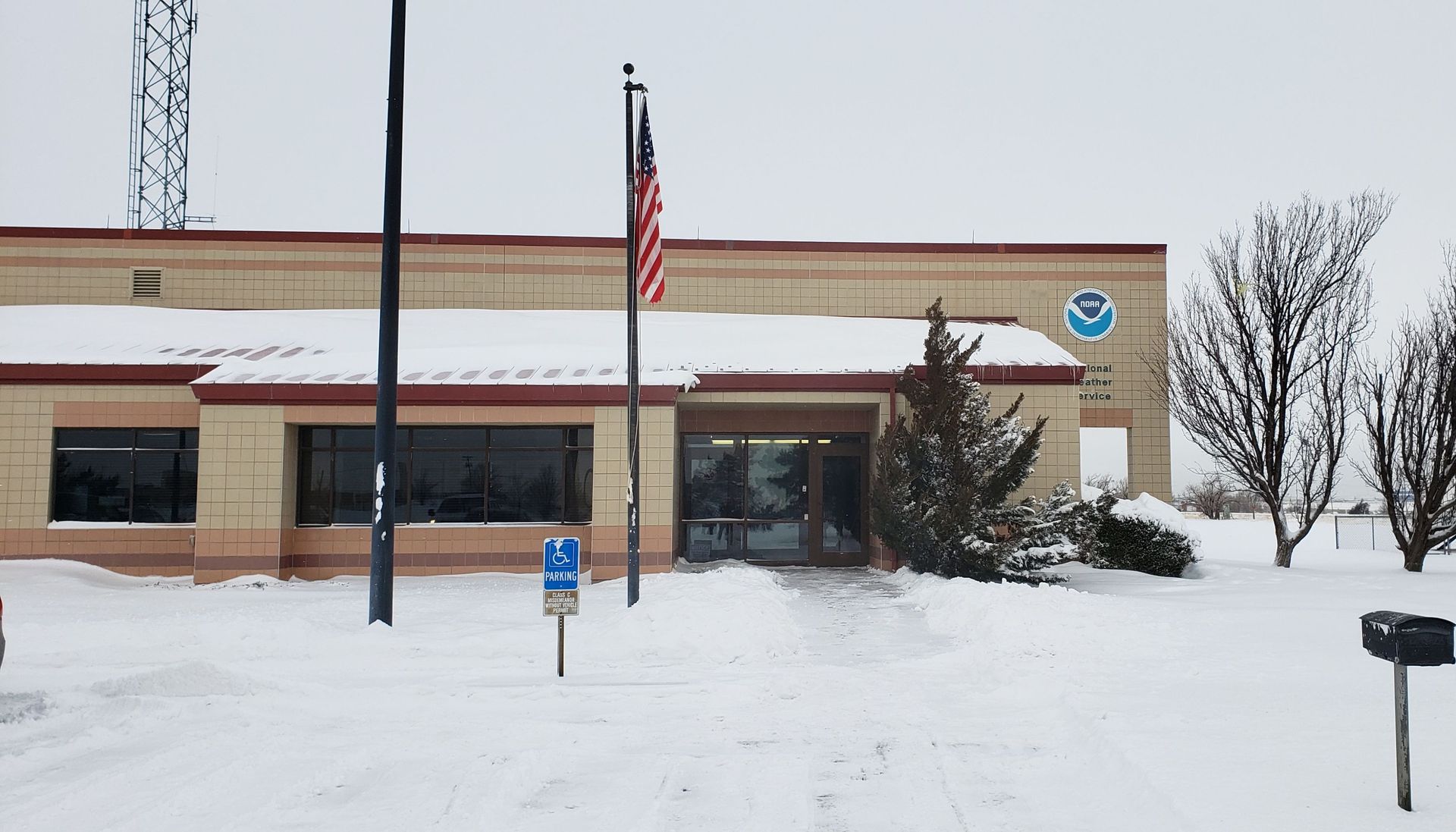 A snowy building with a flag in front of it