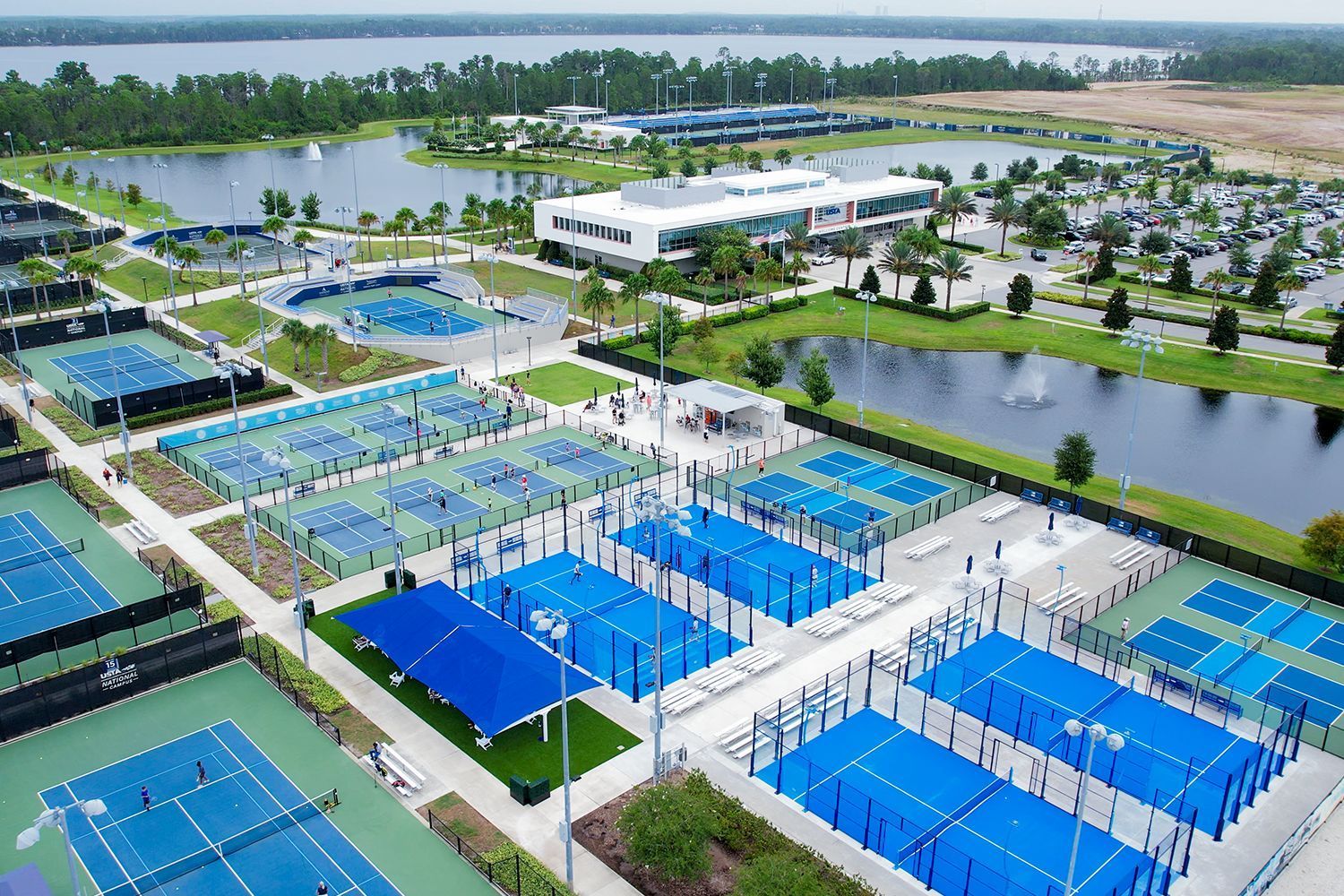 An aerial view of a tennis court with a lake in the background.