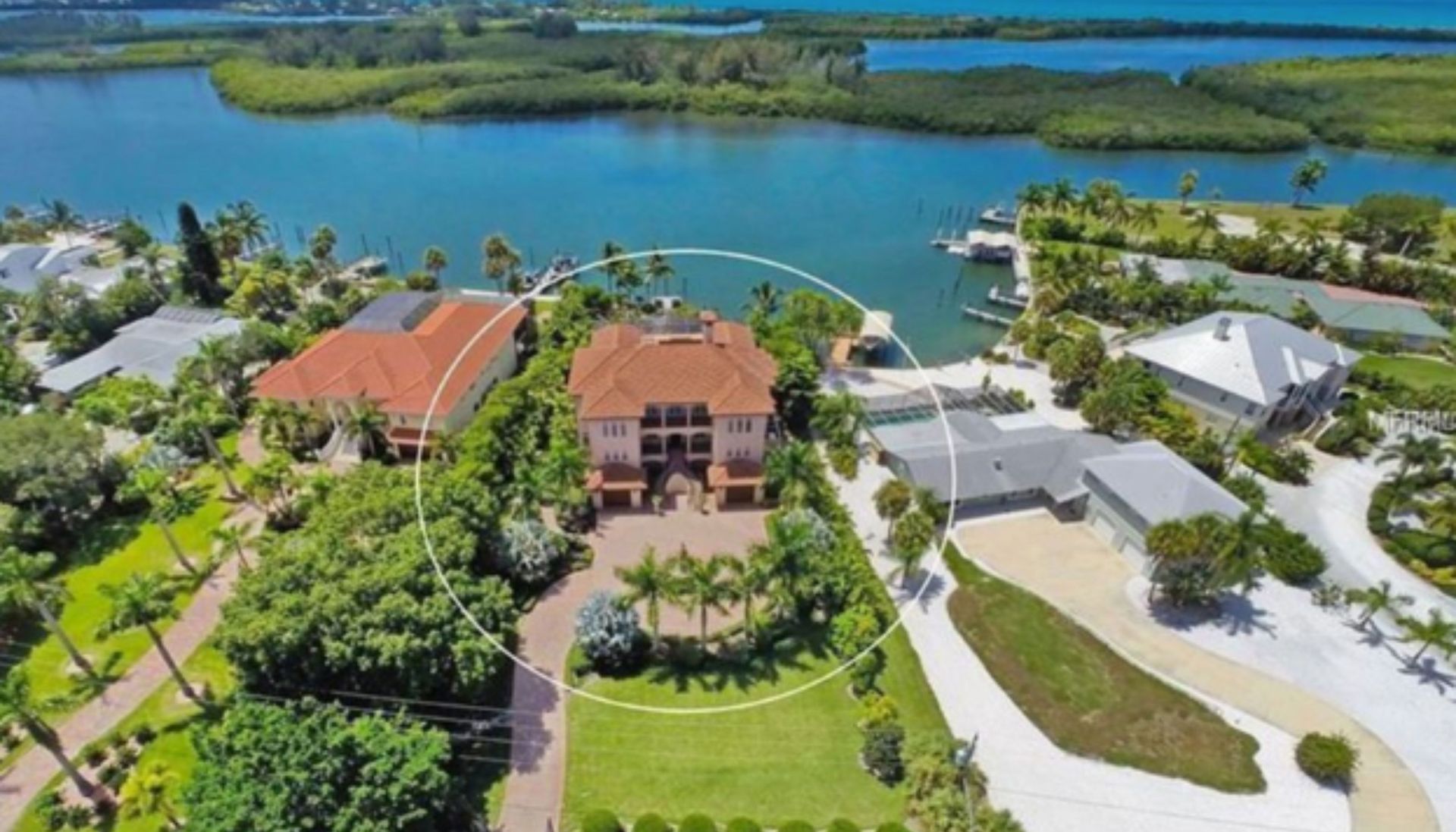 An aerial view of a large house next to a body of water