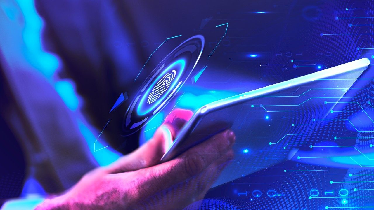 A person is holding a tablet with a fingerprint on it.