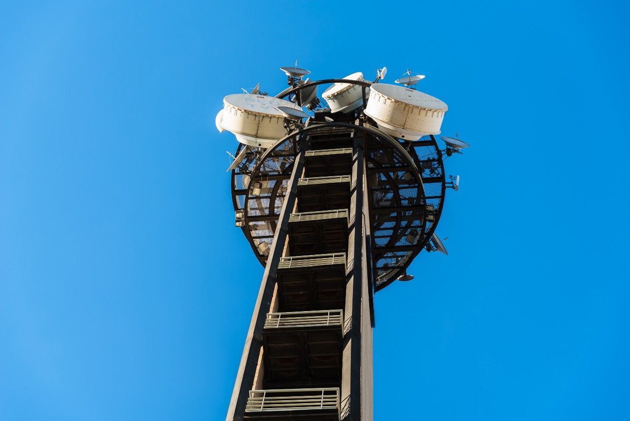 A very tall tower with a blue sky in the background.