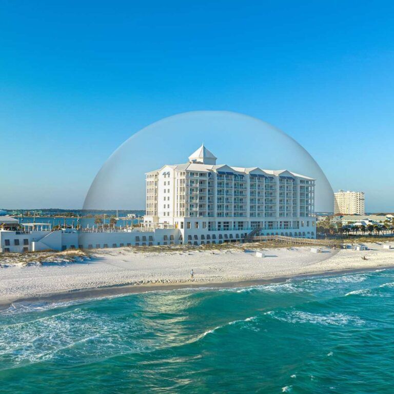 An aerial view of a beach with a large building in the background