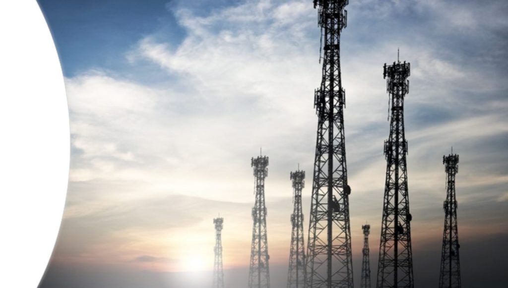 A row of telephone towers against a cloudy sky