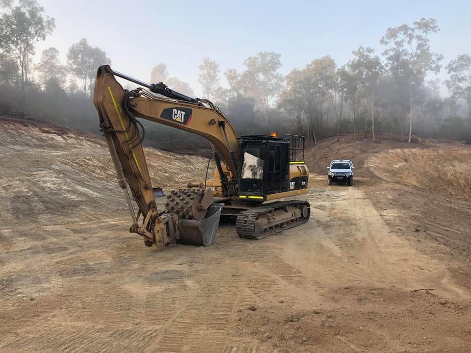 A Yellow Excavator is Parked on the Side of a Dirt Road —  A & B Mullins Excavations Pty Ltd in South Kolan, QLD