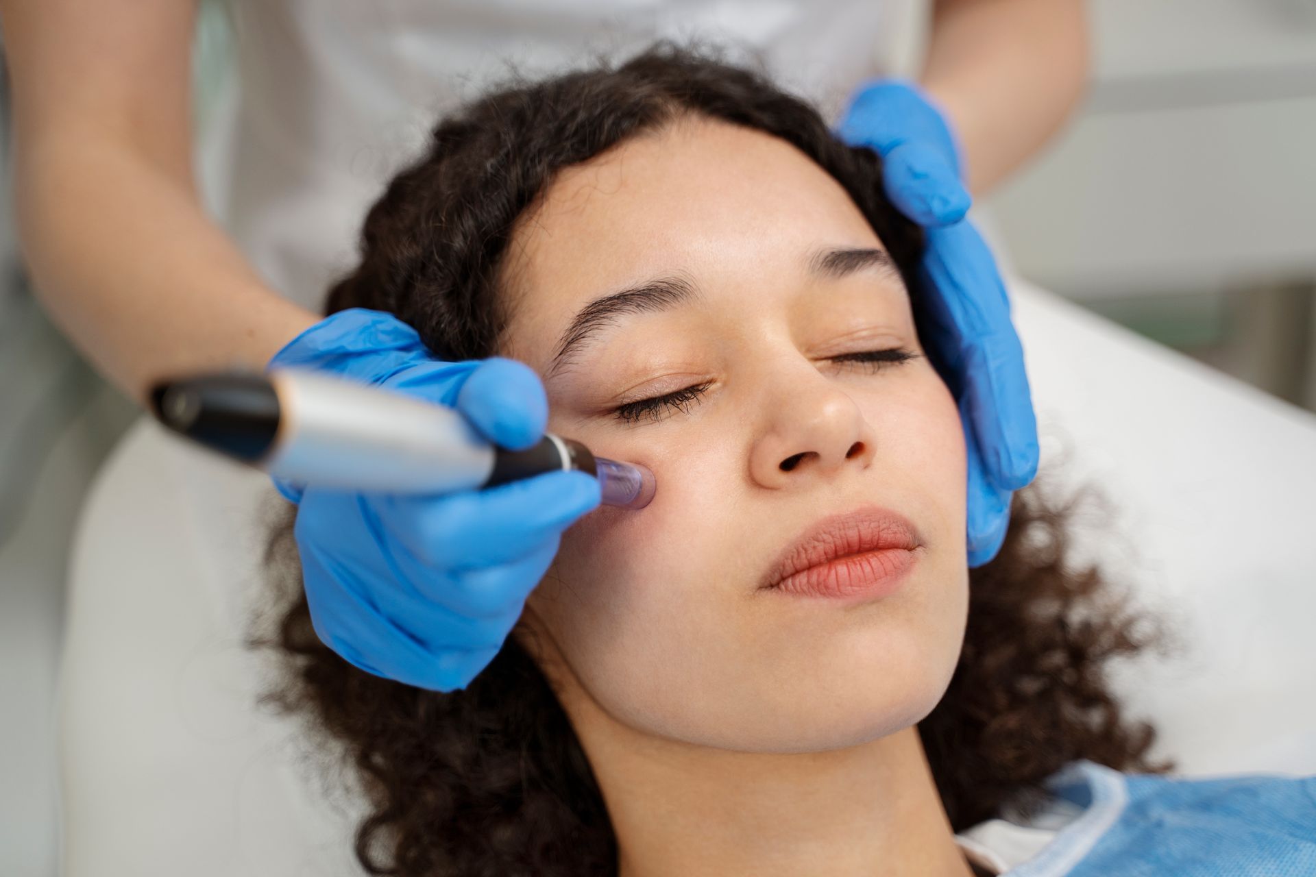 A woman is getting a facial treatment at a beauty salon.