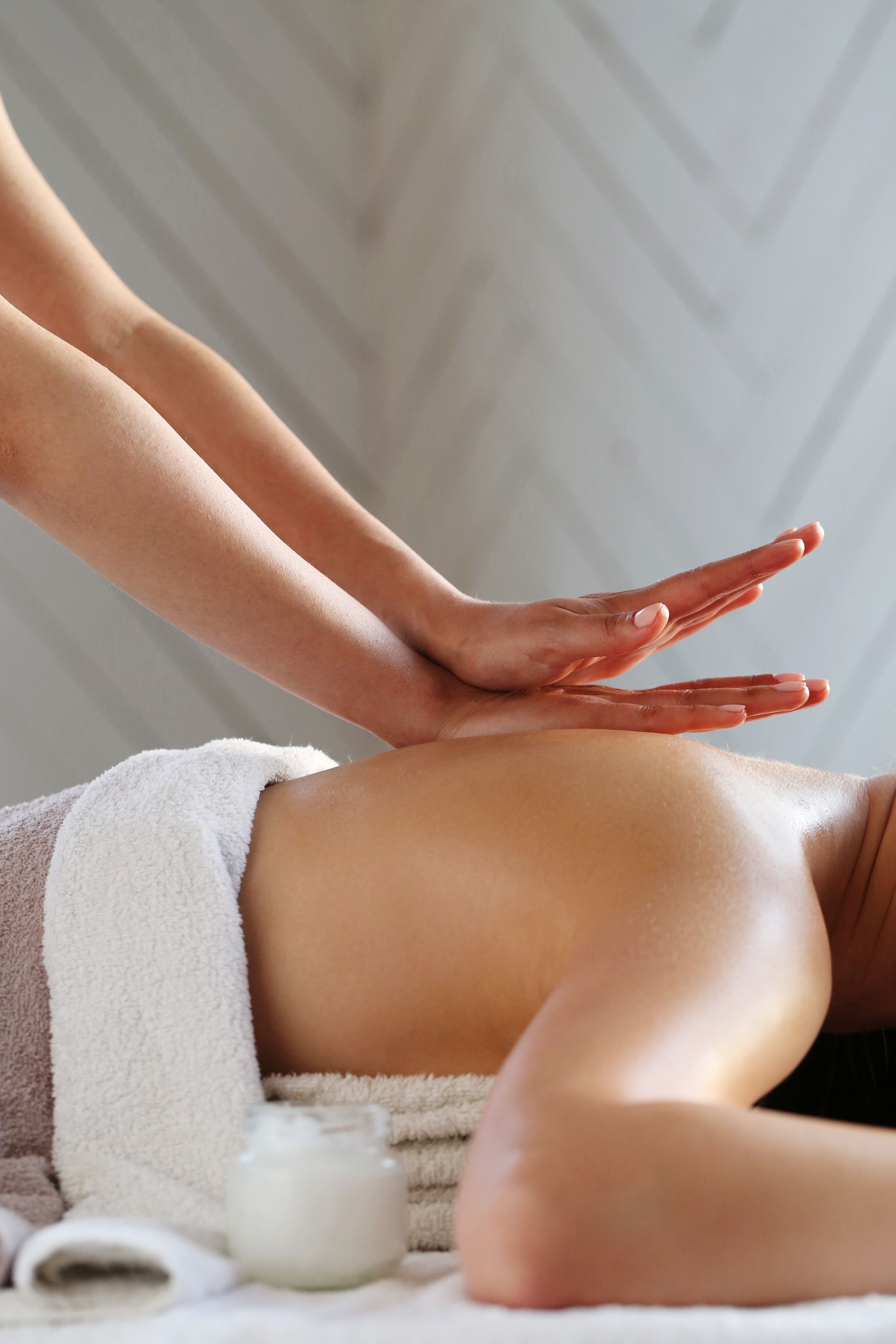 A woman is getting a massage on her back at a spa.