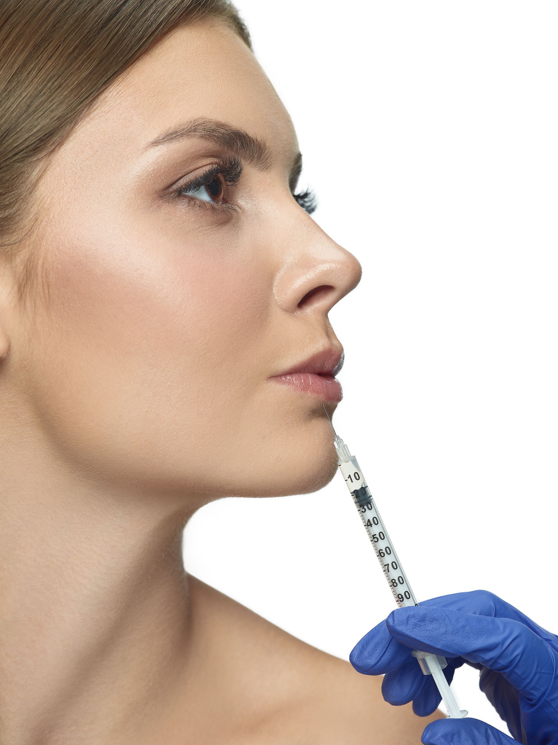 A woman is getting a botox injection in her lips.