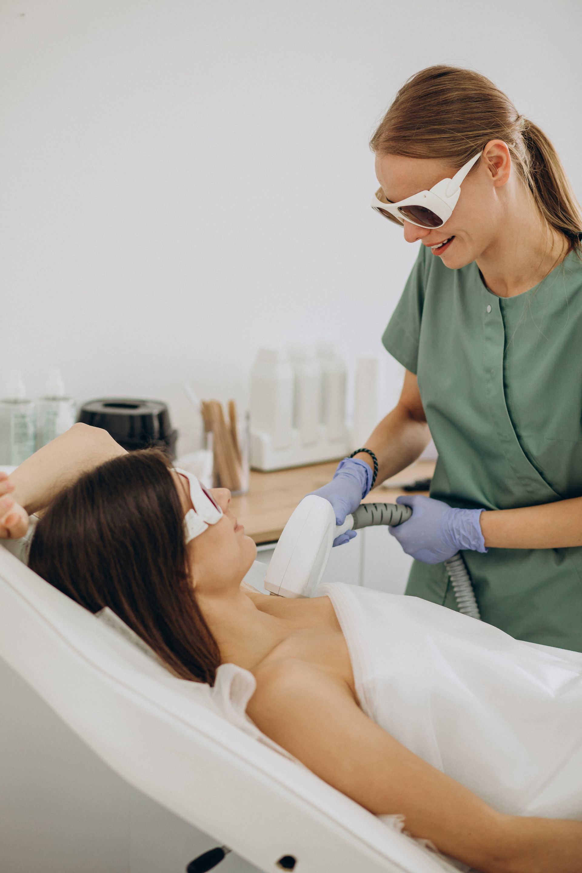 A woman is getting a laser hair removal treatment on her face.