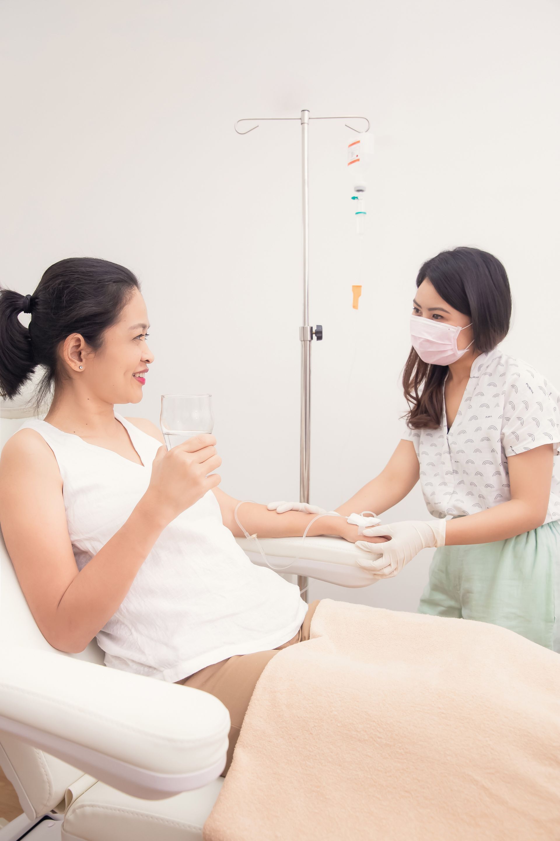 A pregnant woman is getting an injection in her arm.