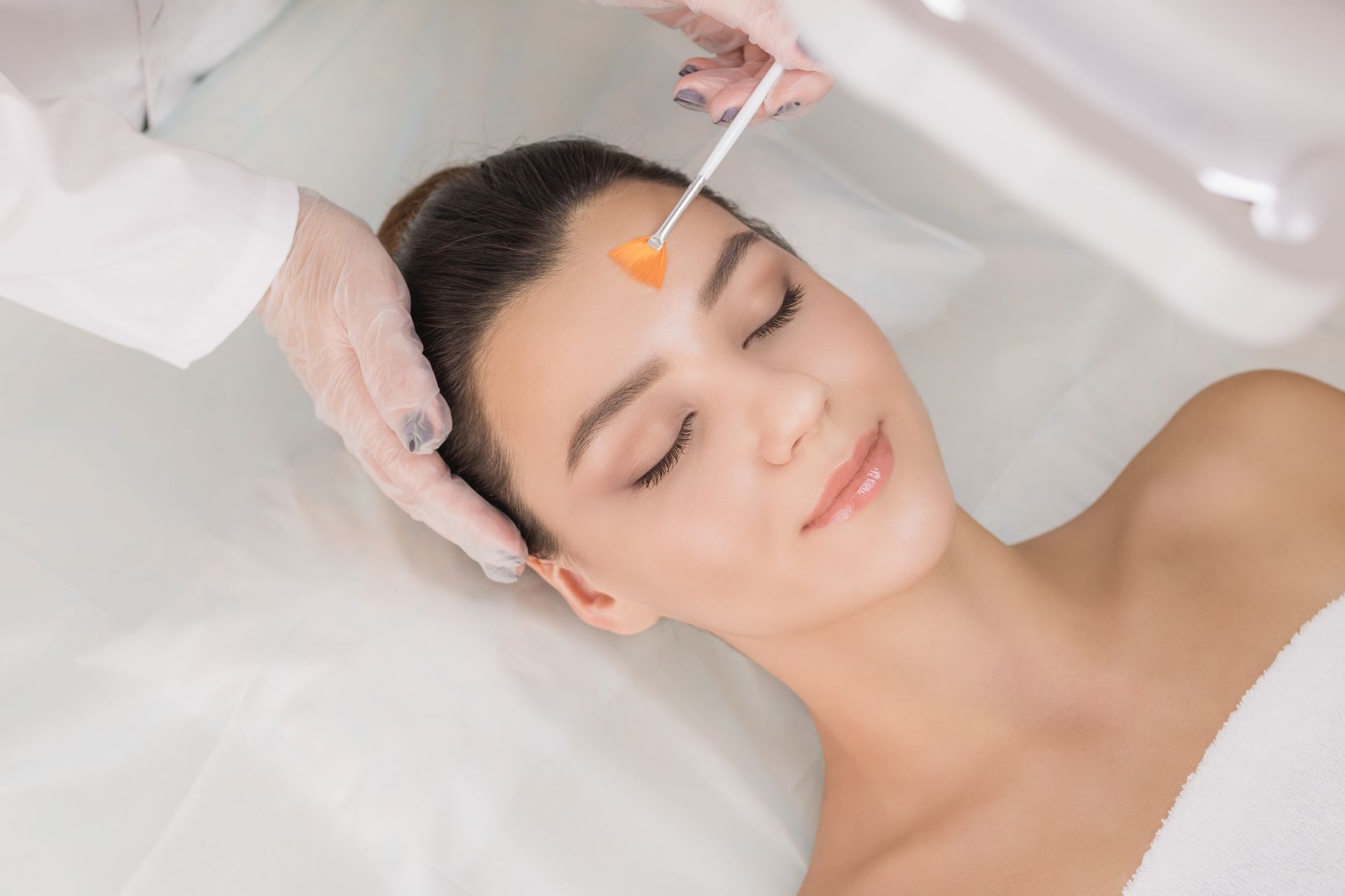 A woman is getting a facial treatment at a beauty salon.